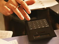 電卓を打つ人の手